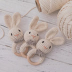 Tres sonajeros de conejito de crochet junto a ovillos de hilo de algodón