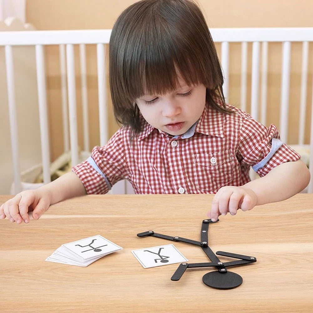 Niña sentada a la mesa copiando una pose con el muñeco articulado