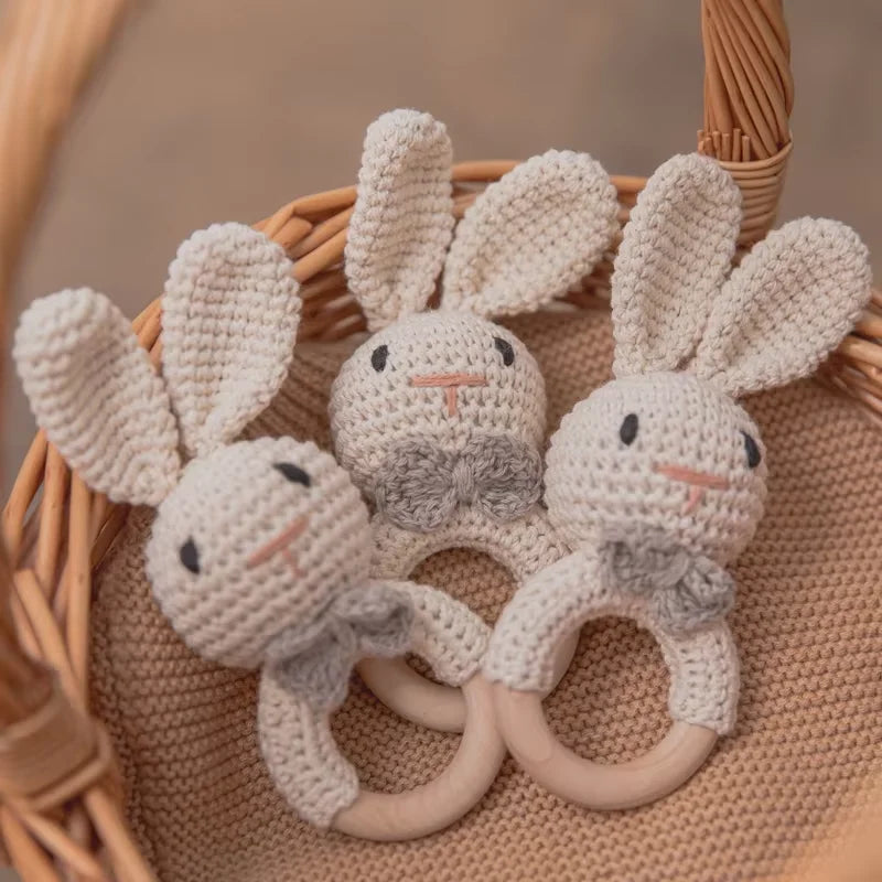 Tres sonajeros de conejito de crochet dentro de una canasta de mimbre