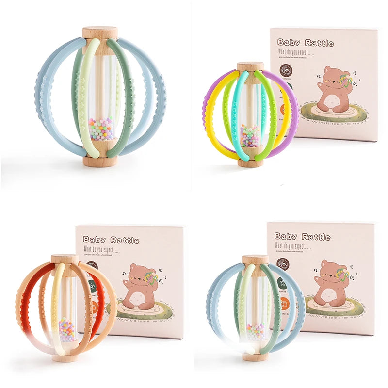 Cuatro sonajeros de madera con aros de silicona en distintas combinaciones de color junto a su caja
