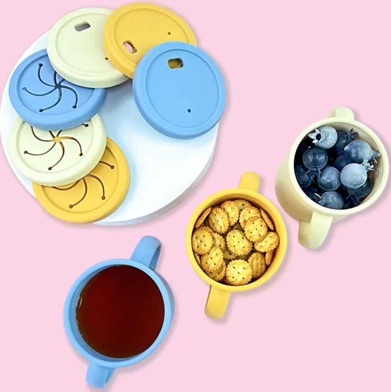 Vasos de silicona con tapa y popote en azul, amarillo y beige con galletas y fruta