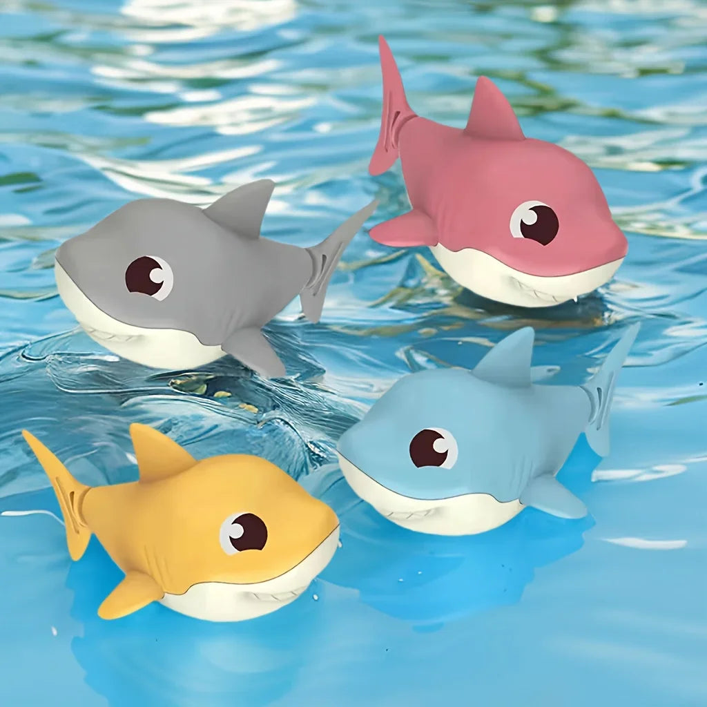Cuatro tiburones de cuerda flotando en el agua: gris, rosa, azul y amarillo