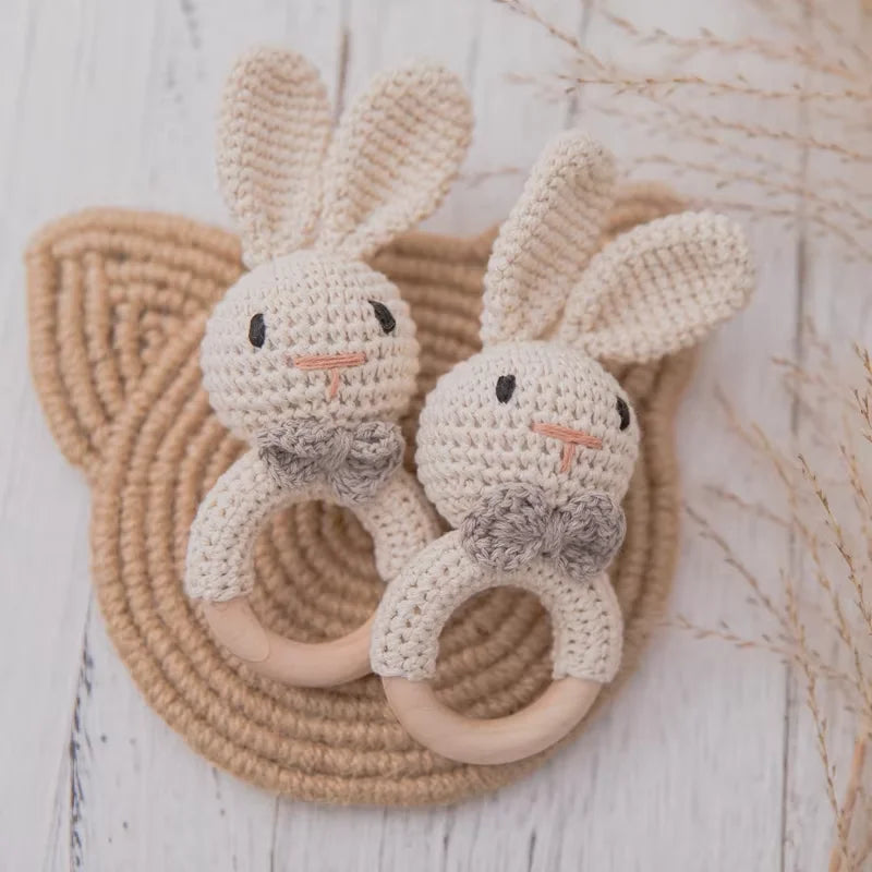 Dos sonajeros de conejito de crochet con aro de madera sobre un tapete tejido